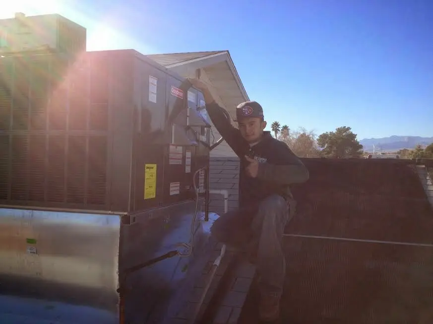 HVAC technician performing AC Tune-Up on a rooftop unit in Littlefield